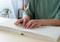 Mani di una persona che legge un libro in braille